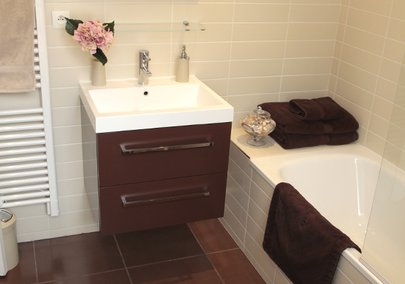 salle de bain équipée d’une baignoire, d’un meuble lavabo, d’un sèche serviette et d’un sèche-cheveux